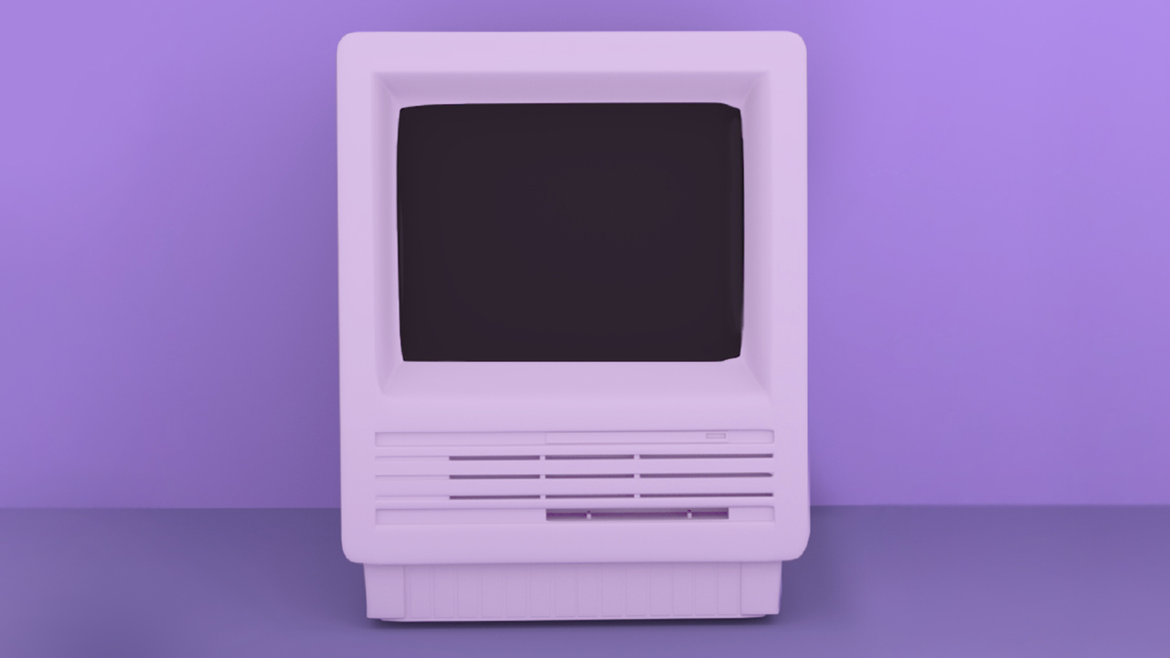 Starý stolní počítač na fialovém pozadí